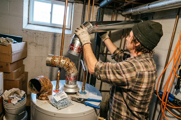 Corroded flue connector replaced with sealed venting above a gas water heater in a semi-detached Toronto home