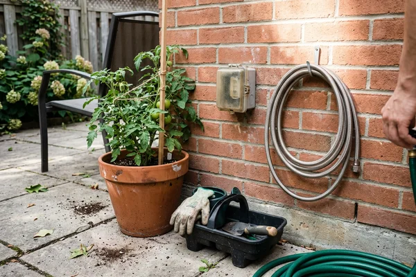 BBQ hookup quick-disconnect gas box on the brick wall of a Toronto home beside a backyard patio