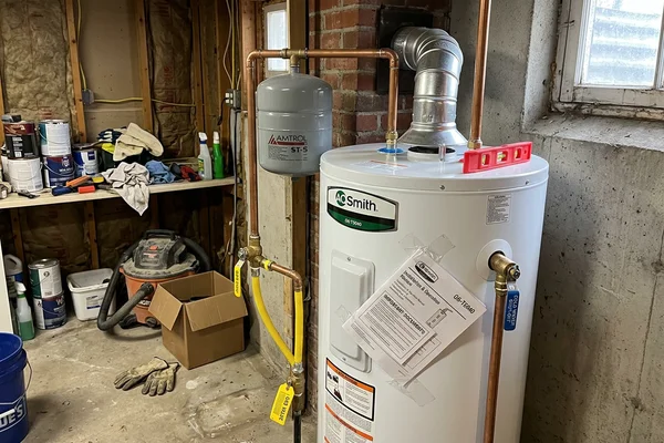 New customer-owned gas water heater with clean venting and expansion tank in a Toronto semi-detached home