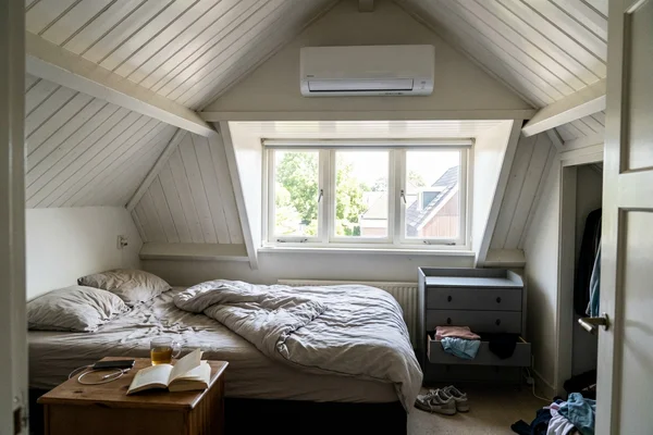 Ductless indoor head installed above a window in the finished attic bedroom of a Toronto semi-detached home